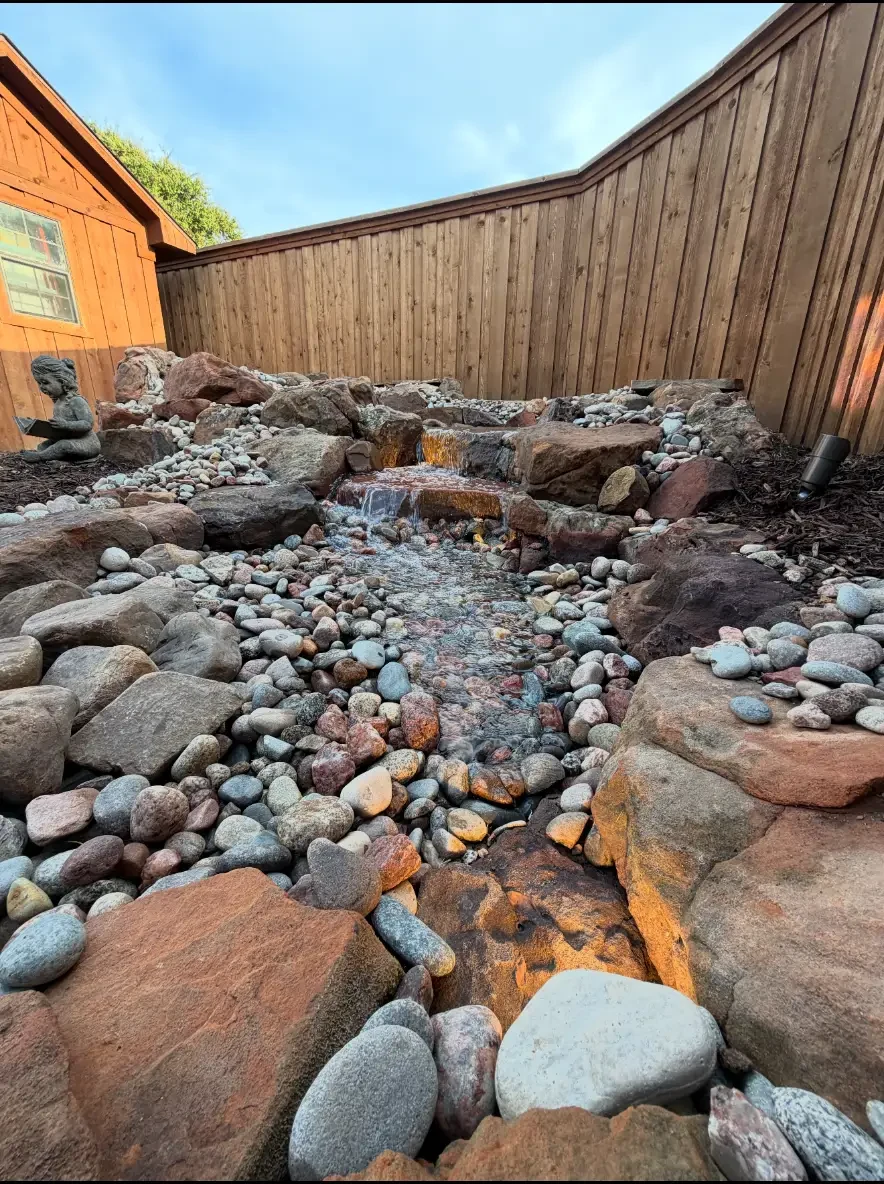 Close view of water flowing through a natural stone backyard stream